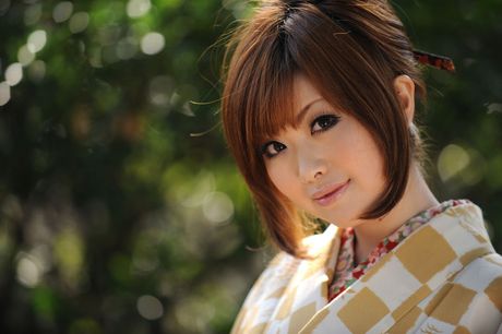 Cute asian model in a yellow kimono showing off her big breasts