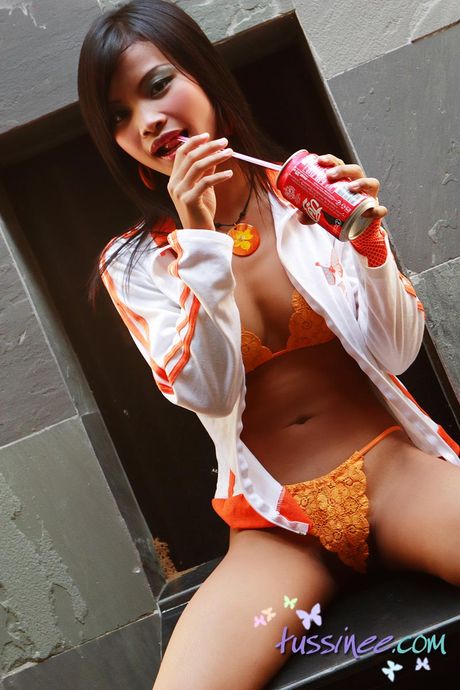 Tussinee posing outdoors sucking on a straw