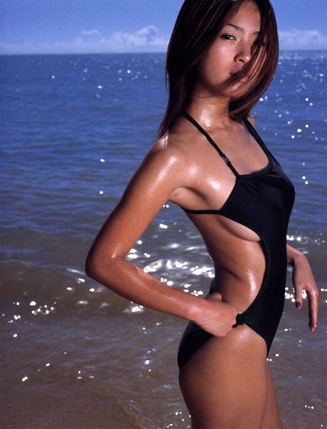 Asian chick is steaming sexy in her black bikini at the beach