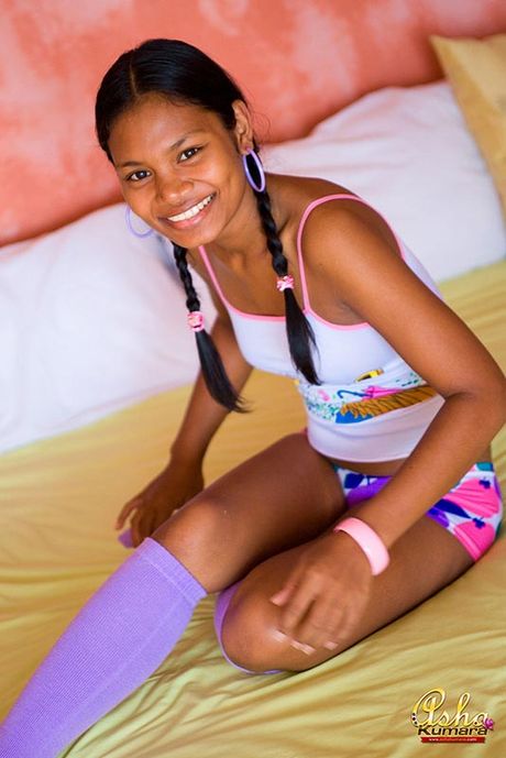 Sexy Indian girl Asha Kumara lays in bed with buns exposed