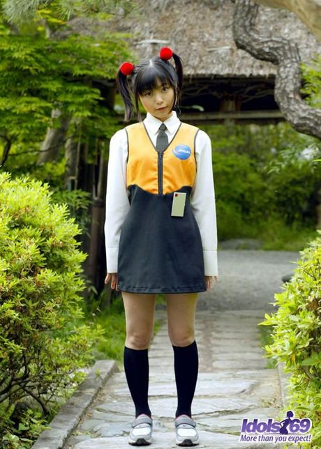 Asian slut in pigtails and uniform shows her hairy pussy and her favorite toys