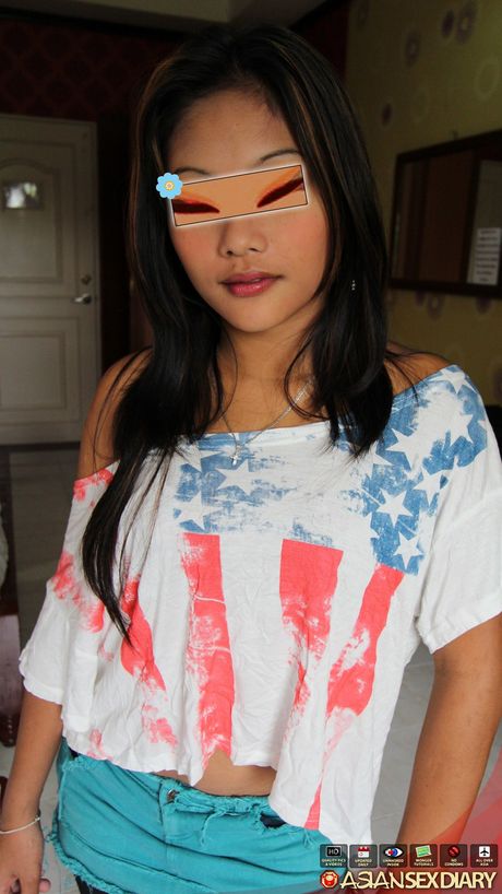 Asian teen Ella strips to her stockings and rubs wet twat on the bed