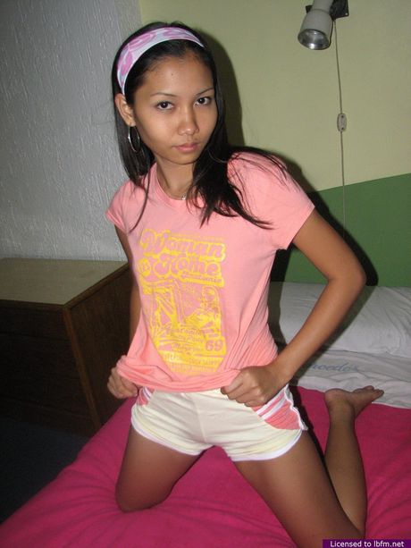 Amateur Asian girl with small tits strips and shows her shaved pussy