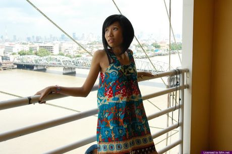 Skinny Japanese lady strips and bares her tiny tits and pussy