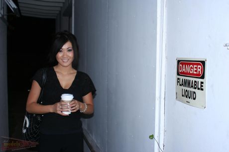 Asian teen Taya strips naked and toys her pussy with a dildo in the kitchen