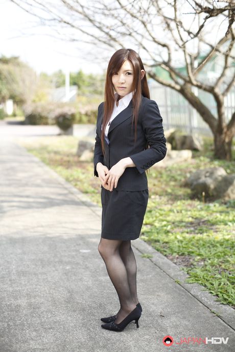 Naughty Hitomi Tsukishiro in office outfit poses so sexy outdoors.