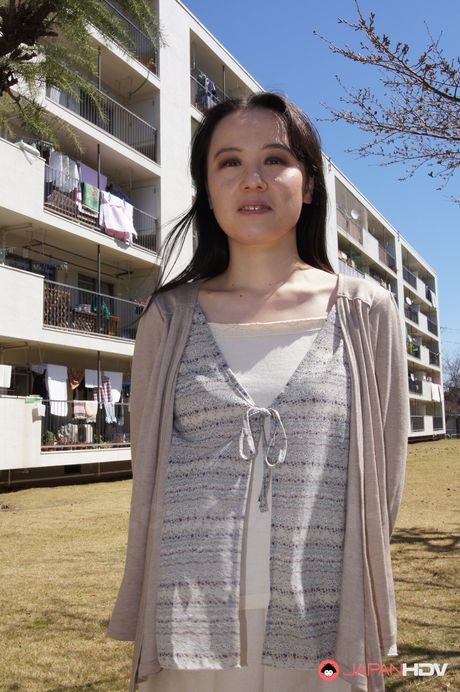 Junko Nishimura is an Asian lady presenting her new outfit outdoors.