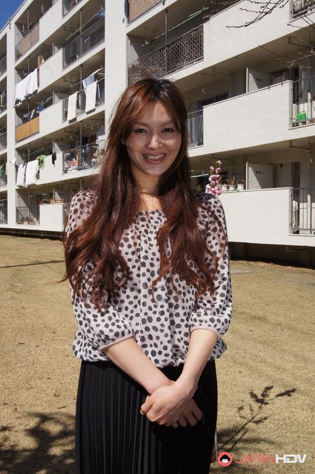 Hitomi Kano with long beautiful hair is happy to pose in neighborhood.